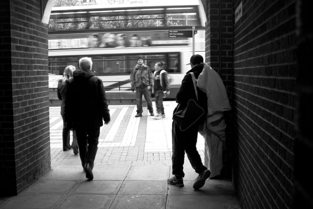 Rough sleeper holding a sleeping bag