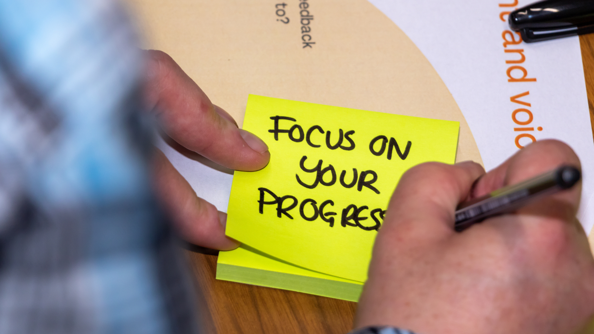 Focus on your progress written on a sticky note