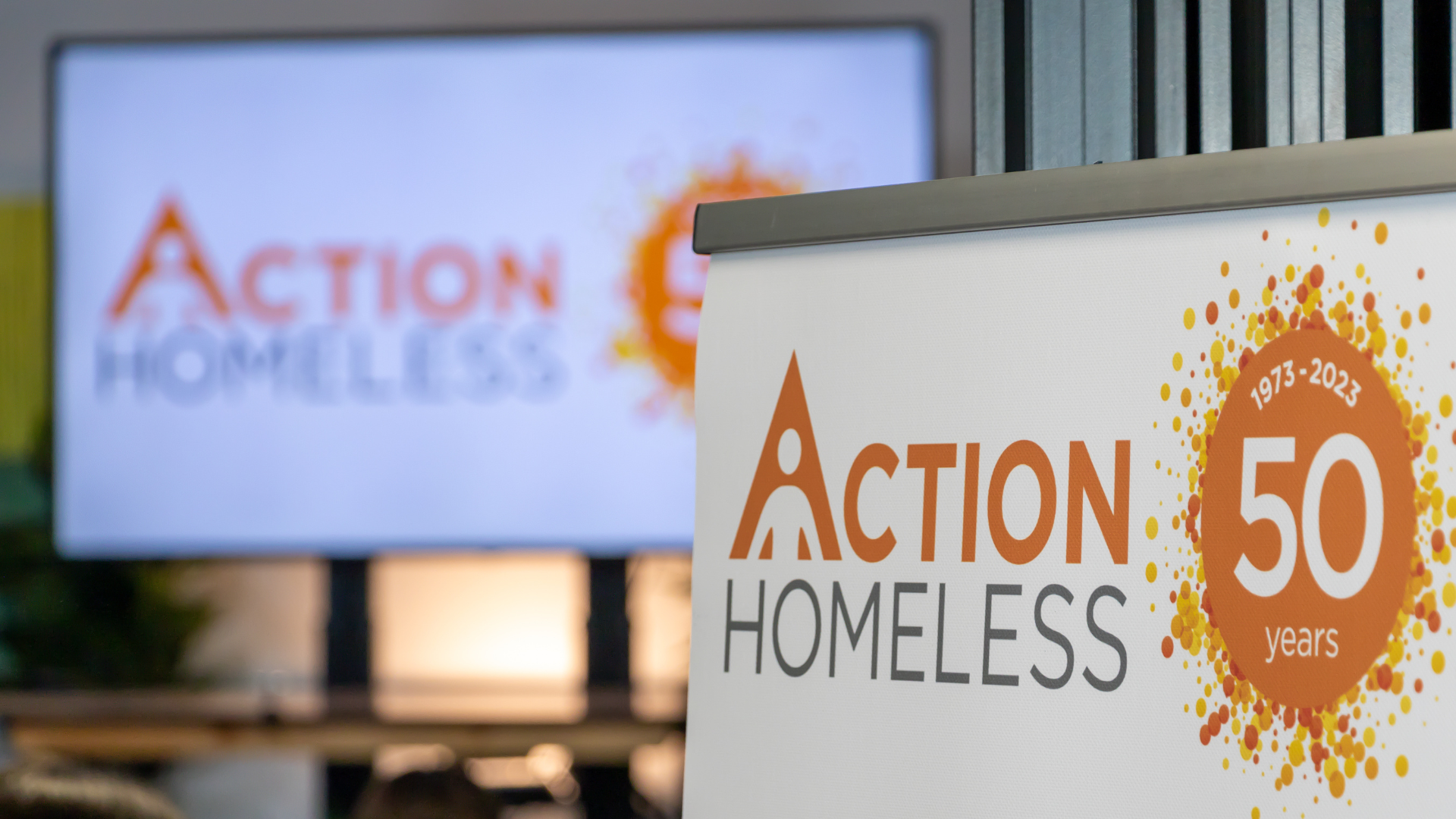 Action Homeless pull up banner with presentation board in the background.